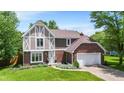 Charming two-story Tudor-style home with a brick and siding exterior, well-manicured lawn, and an attached two-car garage at 9832 Scotch Pine Ln, Indianapolis, IN 46256