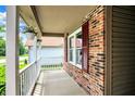 Inviting front porch featuring decorative hanging flowers, brick siding, and white railings at 10412 Cedar Dr, Fishers, IN 46037