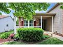 Cozy front porch with hanging plants, brick accents, and a well-maintained garden at 10412 Cedar Dr, Fishers, IN 46037