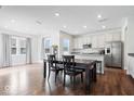 Bright dining area with dark wood floors, white walls, stainless steel appliances, and white cabinets at 10419 Pronghorn Ln, Indianapolis, IN 46239