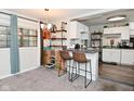 Kitchen featuring white cabinets, laminate countertop, decorative shelving and bar stool seating at 122 E 27Th St, Indianapolis, IN 46205