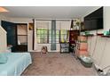 Spacious living room with large window, carpeted floors and tv on wall; view of staircase and front door at 122 E 27Th St, Indianapolis, IN 46205