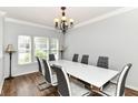 Elegant dining room featuring a bright chandelier, a white dining table and seating for six at 12612 Majestic Way, Fishers, IN 46037