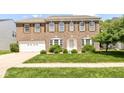 Charming brick home with an attached two-car garage and a lush green lawn with manicured bushes at 12612 Majestic Way, Fishers, IN 46037