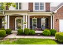 Inviting front porch with stylish seating, vibrant greenery, and an elegant glass door entrance at 14805 Chamberlain Dr, Westfield, IN 46074