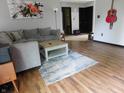 Open-concept living room with hardwood floors, a plush sofa, and eye-catching artwork at 1612 Prairieview Ln, Greenfield, IN 46140