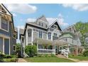 Inviting two-story home with gray siding, front porch with hanging plants, and well-manicured lawn at 1616 N Delaware St, Indianapolis, IN 46202