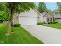 Single-story home features an attached two-car garage, lush landscaping, and a welcoming front entrance at 16768 Maraschino Dr, Noblesville, IN 46062