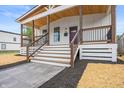 Close-up of a charming covered front porch with wood railings and a modern entrance at 1825 E Maryland St, Indianapolis, IN 46201