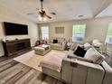 Bright and airy living room with comfortable seating, modern ceiling fan and a sleek entertainment center at 204 Meadow Creek S Dr, Whiteland, IN 46184