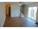 Spacious living room featuring wood floors, a ceiling fan, sliding glass doors, and an open staircase at 2116 Galaxy Dr, Franklin, IN 46131