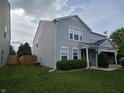 Side view of a well-maintained two-story home featuring a spacious lawn and a wood fence at 3292 Underwood Dr, Whiteland, IN 46184