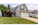 Charming two-story home featuring vinyl siding, brick accents, and an attached two-car garage at 3839 Churchman Woods Blvd, Indianapolis, IN 46203