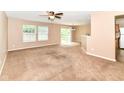 Spacious living room with neutral carpet, fan and plenty of natural light at 3839 Churchman Woods Blvd, Indianapolis, IN 46203