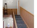 Carpeted staircase with wooden railing and trim providing access to different floors at 404 E New York E St # 406, Indianapolis, IN 46202