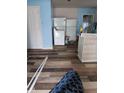 Incomplete room with blue walls, a door, hardwood floors, and a large refrigerator unit at 4106 N Pasadena Ave, Indianapolis, IN 46226