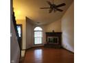 Spacious living room featuring a brick fireplace, hardwood floors, a ceiling fan, and a large window at 4336 Abby Creek Ln, Indianapolis, IN 46205