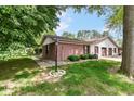 Exterior view with brick accents, lush lawn, and the convenience of an attached garage at 4504 Harvard Dr, Anderson, IN 46013