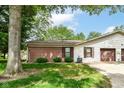 Side exterior featuring brick accent, vinyl siding, a well-kept lawn, and an attached garage at 4504 Harvard Dr, Anderson, IN 46013