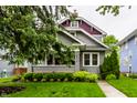 Attractive two-story home with a well-manicured lawn, mature landscaping, and covered porch at 5015 N Park Ave, Indianapolis, IN 46205