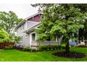 Side angle view of a well-kept home with mature trees and lush lawn at 5015 N Park Ave, Indianapolis, IN 46205