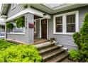 Covered front porch with traditional columns and lush landscaping surrounding entrance at 5015 N Park Ave, Indianapolis, IN 46205
