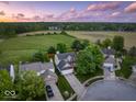 Aerial view of a house with a large lawn, set in a neighborhood with a country-like backdrop at 5041 Millwright Ct, Indianapolis, IN 46254