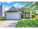 Charming two-story home featuring a two-car garage, covered porch, and a well-maintained front lawn at 5041 Millwright Ct, Indianapolis, IN 46254