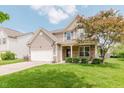 Charming two-story home featuring a two-car garage, well-manicured lawn, and inviting front porch at 5913 Monticello Square Ln, Indianapolis, IN 46234