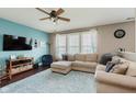 Comfortable living room with a large sectional couch, ceiling fan, hardwood floors, and a wall-mounted TV at 5913 Monticello Square Ln, Indianapolis, IN 46234