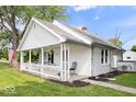 Quaint single-story home with a covered front porch, fresh exterior paint, and well-kept landscaping at 606 E County Line Rd, Indianapolis, IN 46227