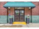 Inviting entrance with a green awning, planters, and double doors showcases the building's address at 630 N College Ave # 105, Indianapolis, IN 46204