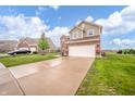 Suburban home featuring a two-car garage, well-maintained lawn, and a paved driveway at 6579 Aster Dr, Pendleton, IN 46064