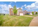 Residential street showcasing a well-maintained green lawn and inviting home exterior at 6579 Aster Dr, Pendleton, IN 46064