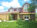 Well-maintained townhouse featuring mature landscaping, a two-car garage, and a welcoming front entrance at 6723 Silver Tree Dr, Indianapolis, IN 46236