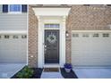 Inviting front entrance with decorative wreath, elegant trim, and 'wipe your paws' welcome mat at 6871 Adalene Ln, Carmel, IN 46033