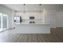 Open concept kitchen features a large island, stainless steel appliances, white cabinets, and stylish pendant lighting at 6871 Adalene Ln, Carmel, IN 46033