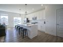Bright, open kitchen with white cabinets, stainless steel appliances, and large center island at 6871 Adalene Ln, Carmel, IN 46033