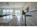 Modern kitchen featuring white cabinets, stainless steel appliances, and a large island with seating at 6871 Adalene Ln, Carmel, IN 46033