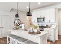 Bright kitchen featuring white cabinets, stainless steel appliances and a center island with seating at 7258 Selah Ln, Noblesville, IN 46062
