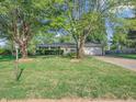 Well-maintained home with mature trees, a large front yard, and a paved driveway at 726 Coach Rd, Indianapolis, IN 46227