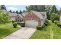 Charming brick home featuring manicured landscaping and an attached two car garage at 7335 Pymbroke Dr, Fishers, IN 46038