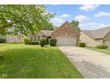 Charming brick home featuring manicured landscaping and a two-car garage at 7335 Pymbroke Dr, Fishers, IN 46038
