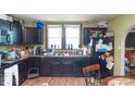 Functional kitchen with dark cabinetry, black appliances, and a view of the window at 829 Waldemere Ave, Indianapolis, IN 46241