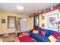 Bright living room with a plush blue sofa, red rug, and a view of the front door at 829 Waldemere Ave, Indianapolis, IN 46241