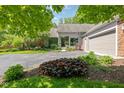 Inviting home exterior with beautiful landscaping, a gray facade, and mature trees providing shade at 8330 Claridge Rd, Indianapolis, IN 46260