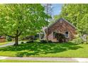 A brick home with a star decoration and a well-kept lawn provides classic curb appeal at 8330 Claridge Rd, Indianapolis, IN 46260