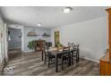 Bright dining room with hardwood floors, large windows, stylish decor, and seating for six guests at 8581 N Goat Hollow Rd, Mooresville, IN 46158