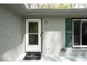 Close up of a well-lit entryway with a 'welcome' mat, green shutters, and a white painted brick exterior at 8581 N Goat Hollow Rd, Mooresville, IN 46158