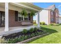 Shows landscaped porch with a swing; a perfect place to relax and enjoy the outdoors at 8635 Nolan Dr, Fishers, IN 46038